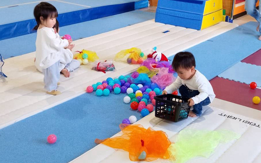 スカーフ、ボール遊びをする女の子と男の子の写真